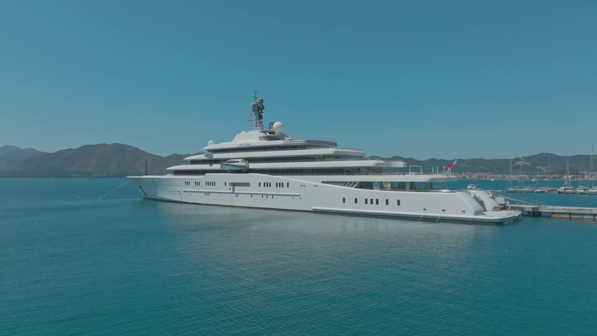 Luxury yacht docked in a sunlit coastal marina